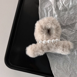 Vista dettagliata della pinza per capelli in peluche albicocca con perle per l'inverno