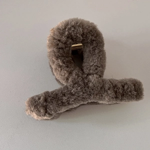 Vue détaillée de la pince à cheveux en peluche gris foncé avec fausse fourrure et ressort