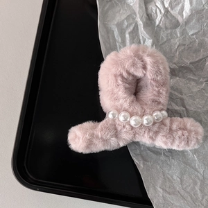 Dettaglio della molletta per capelli in peluche rosa con ecopelliccia e perle bianche