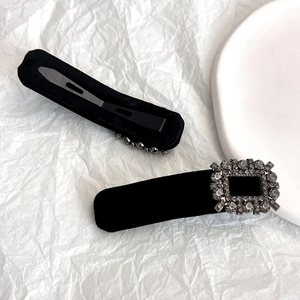 Elegant black velvet hair clip set with sparkling square rhinestones on a white background