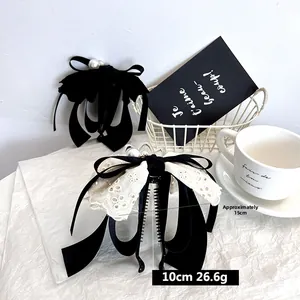 Detail view of 15cm fabric bow hair clips with velvet and lace texture on a white basket
