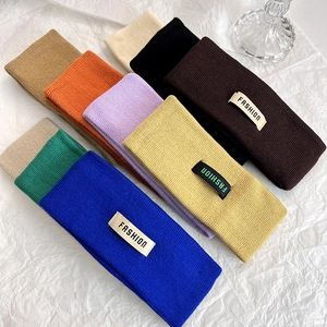 Posa piatta di nove fasce per capelli in maglia colorata con etichette Fashion su carta bianca