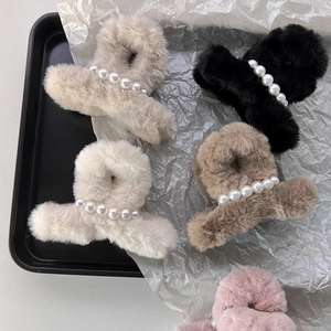 Dettaglio della pinza per capelli in pelliccia sintetica con eleganti perle per l'inverno