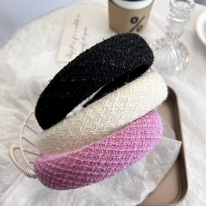 Macro view of thickened tweed headbands in pink, cream, and black with shiny metallic thread