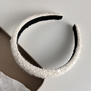 Detail of elegant white tweed headband with shimmering sequins and black non-slip lining