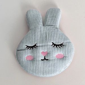 Macro detail of cute light blue corduroy bunny hair clip with soft embroidered face details