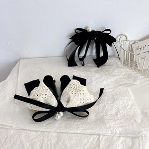 Detail of velvet and lace bow banana hair clips with elegant pearl embellishments