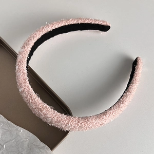 Detail of pink plush headband with sequins and non-slip lining on a metal tray