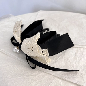 Detailed view of French vintage banana hair clip with black satin, lace and pearl charms
