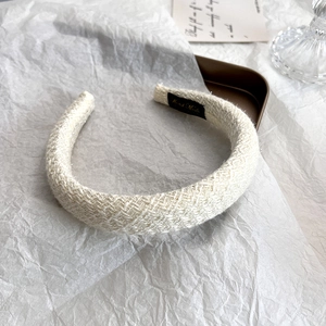 Detail of tweed headband texture and Hand Made label on cream fabric hair accessory