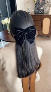 Elegant large black velvet bow hair clip worn on the back of the head for a chic look