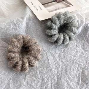 Detail of wool-textured telephone wire hair ties in grey and coffee colors with warm fibers
