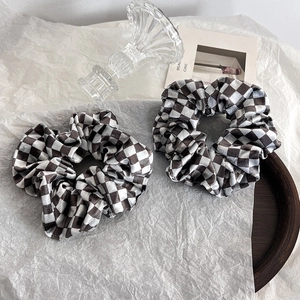 Set di due elastici per capelli in velluto a scacchi marroni e crema su vassoio
