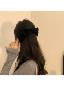 Detailed back view of a black velvet bow hair clip on elegant half-up hairstyle