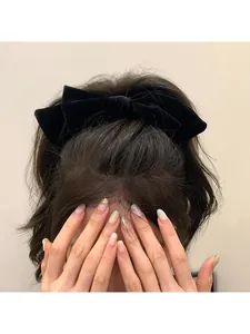 Detailed back view of a large black velvet bow hair clip with layered 3D texture and spring