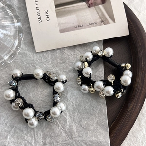 Détail d'un ensemble d'élastiques à cheveux avec perles blanches et strass en cristal