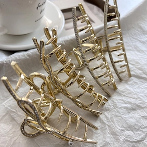 Elegante Haarklammern aus Goldlegierung mit Diamanten und Perlen auf weißem Grund