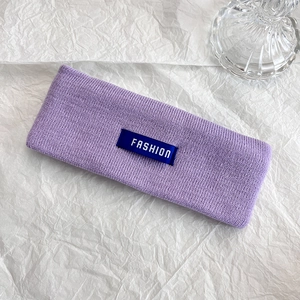 Dettaglio della fascia lavorata a maglia viola con etichetta fashion su carta bianca