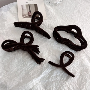 Detailed view of four brown flocked hair claws with velvet texture on white paper