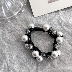 Détail d'un chouchou fait main avec perles d'imitation blanches et perles de cristal