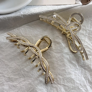 Detailansicht der goldenen Haarklammern mit weißen Strasssteinen und Perlendetail