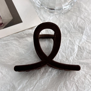 Close-up of a minimalist dark brown flocked hair claw clip with smooth velvet texture