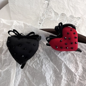 Detail of red and black velvet heart hair claws with rhinestone studs and ribbon bow