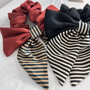 Elegant satin bow scrunchies with retro stripes in red and black colors for hair styling