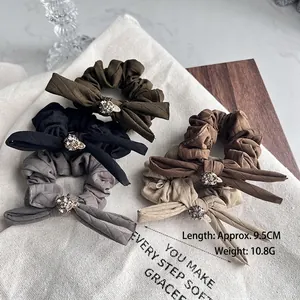 Quilted bow hair scrunchies set with rhinestones in olive green, black, and beige colors