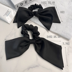 Elegant black satin oversized scrunchie set with bow design on marble surface