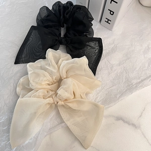 Détail de chouchous à nœuds en organza noir et beige élégants sur papier texturé
