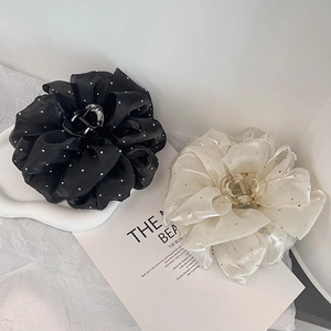 Détail des pinces à cheveux françaises de 11cm en tissu noir et blanc avec strass brillants
