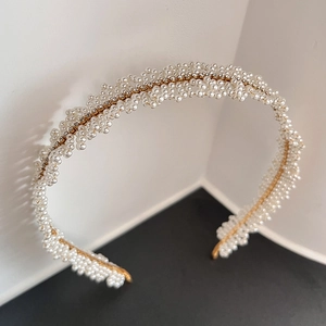 Elegant pearl and rhinestone headband with gold metal base for a sophisticated bridal look