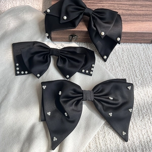 Detailansicht der schwarzen Satin-Haarspangen mit eleganten Perlenverzierungen