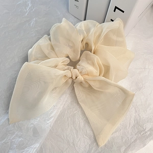 Détail du chouchou en organza crème avec nœud montrant la texture délicate du tissu fin