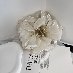 Détail d'une grande pince à cheveux fleur en tissu blanc de 11cm avec cristaux