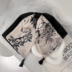 Détail de la pince à cheveux avec nœud style peinture à l'encre et glands en soie noire