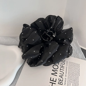 Grosse pince à cheveux fleur noire en maille ornée de strass argentés étincelants