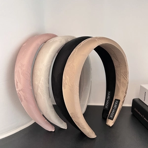 Detail of four padded jacquard headbands with handmade labels in soft vintage colors