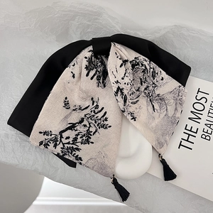 Détail de la pince à cheveux avec peinture à l'encre de chine et glands en velours noir