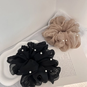 Detail of large organza hair scrunchies in black and beige with elegant pearl bead accents