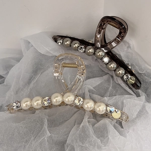 Détails de pinces à cheveux de luxe avec perles et strass sur fond de papier blanc