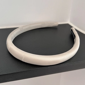 Detailed shot of champagne satin headband showing the inner handmade textile label