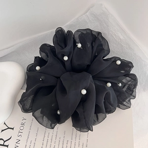 Close-up of black oversized mesh scrunchie with elegant pearl embellishments