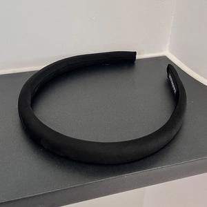 Close-up of a handmade black sponge headband featuring soft velvet texture and inner tag