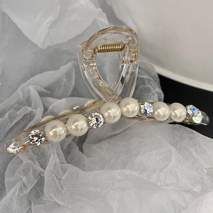 Gros plan détaillé d'une pince à cheveux en acrylique avec perles et strass brillants