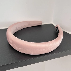 Detail of pink jacquard padded headband with silk texture and Hand Made fabric label