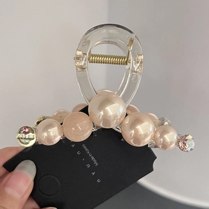 Detail of elegant hair claw clip with champagne faux pearls and pink rhinestones