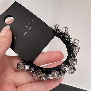 Detail view of handmade crystal bead elastic hair tie with luxury woven black rope texture