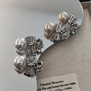 Elegant silver bow earrings with large faux pearls and zircon texture in a vintage style